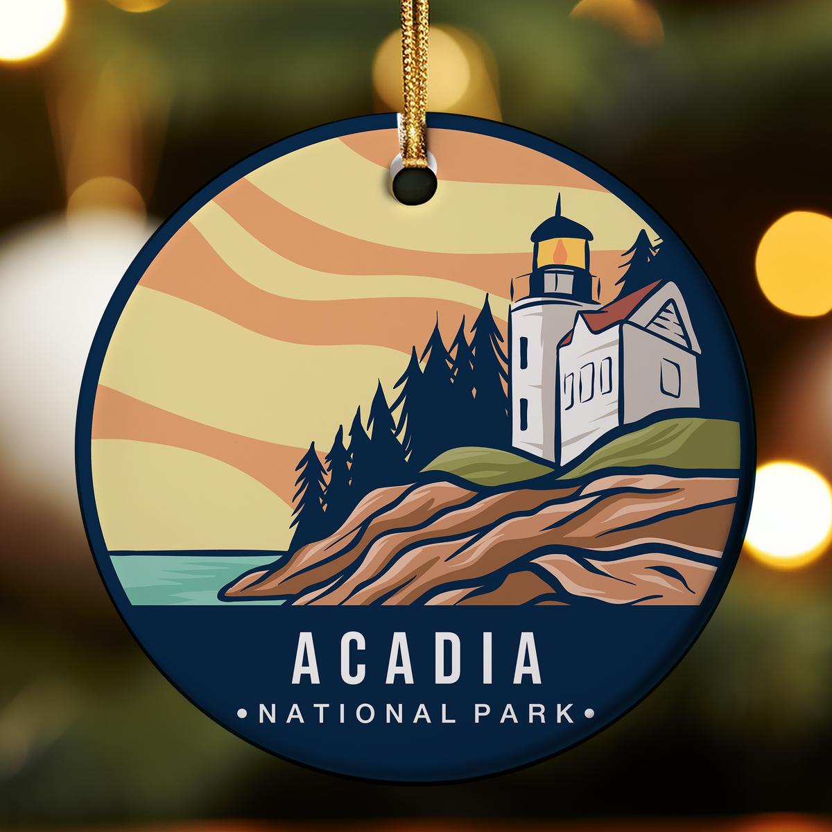 A scenic, round illustration celebrating Acadia National Park in Maine. The design presents a coastal landscape where a rugged shoreline meets the ocean. The foreground features rocky tide pools and patches of sand, leading up to a rugged, cliff-like formation covered in dense, autumnal forestation. The background features layered blues of the sea and sky, with a warm, setting sun casting an orange glow over the scene. The gracefully scripted text "Acadia MAINE" is overlaid on the tranquil horizon line.
