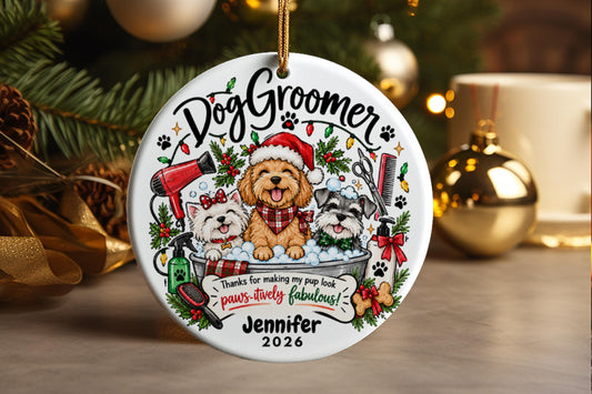 This personalized round ornament features a delightful scene celebrating a dog groomer. The design centers around a friendly, bearded dog wearing a festive Santa hat, situated above a basin where two smaller companion dogs are receiving grooming. The seeing is rich with holiday cheer, complemented by various grooming tools like clippers, combs, and scissors, alongside decorative elements such as greenery garlands and red bows. The ornament is inscribed with the Title "Dog Groomer" at the top.