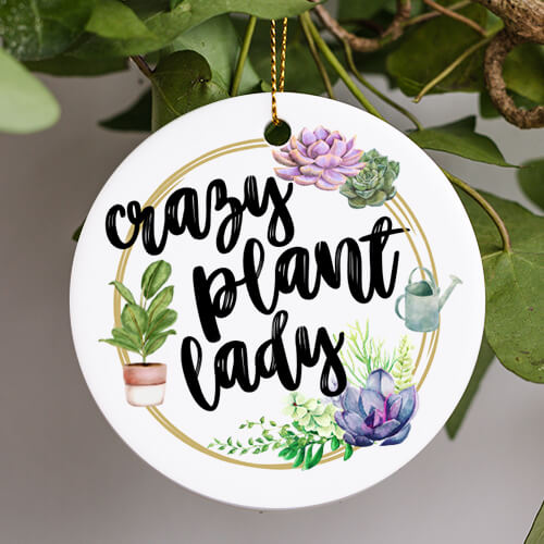 This Everyday Ornament is a watercolor image of succulents a watering can and gold wreath. The words crazy plant lady are in a whimsical black ink brush script font.