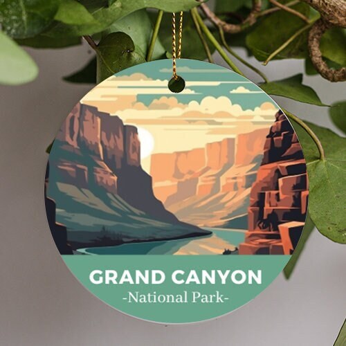 This holiday ornament shows the peaks of the Grand Canyon valley with flowing river. Warm sugary colored pastels accent the rock face from the sun and fluffy clouds of the illustration. Grand Canyon National Park is displayed at the bottom.