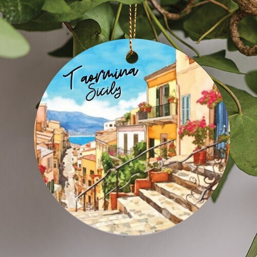 This holiday ornament shows Taormina Sicily. With its chic spectacular view of the turquoise sea in the background just hinting at the mountains in the rear.  The small walkable streets lined with flowers.