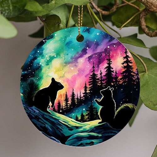 This holiday ornament shows the colorful Northern Lights. Pine trees and snow mounds. As a couple of squirrels admire the nights starry colorful sky.