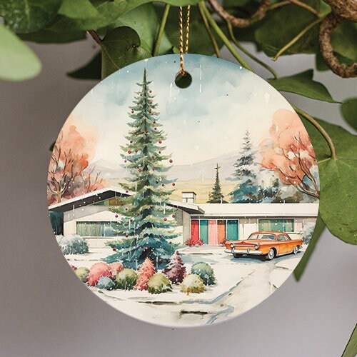 This holiday ornament shows a retro vintage ranch home with car in driveway as snow falls and freezes on the Christmas tree in watercolor style painting.