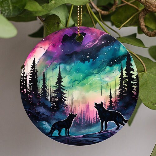 This holiday ornament shows the colorful Northern Lights. Pine trees and snow mounds. As a pack of wolves admire the nights starry colorful sky.