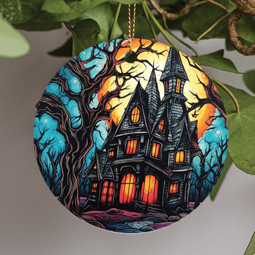 This halloween holiday ornament is in a modern surreallist art style of a thirteen windowpane haunted house. Eerie shingles decorate the roof in various gray tones complementing the wooden boards used for the rest of the structure of the house. A blue nights sky peeks through the scattered bare creepy trees and autumn moon overhead.